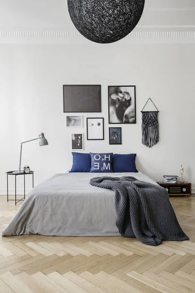卧室配有特大号床 蓝色枕头 灰色羽绒被和毯子 墙上的框架艺术品画廊 真实照片概念 — 图库照片
