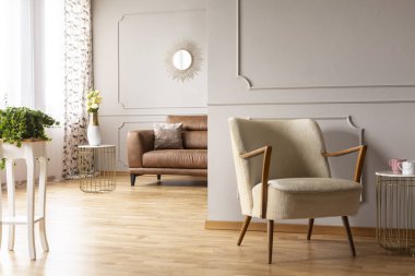 Yeşil bitki tablo, antika koltuk, çiçekli vazo ve konforlu deri kanepe yastık modern daire geniş oturma odasında ile