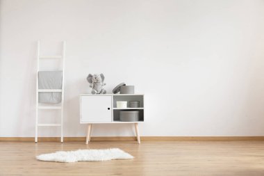 Beyaz Oda iç çocuk ile tüylü halı, yorgan merdivenle ve fil ve kutuları ile dolap için gerçek fotoğraf. Senin beşik için boş yer