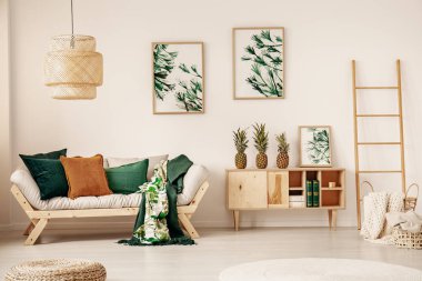 Beyaz Salon iç kanepe yastık ve battaniye, duvar ve üç ananas ile ahşap dolap asılı poster ile gerçek fotoğraf