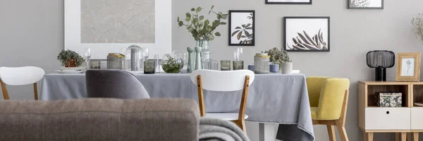 食器とテーブルで椅子とダイニング ルームのインテリアに灰色の壁にポスターのパノラマ 実際の写真 — ストック写真