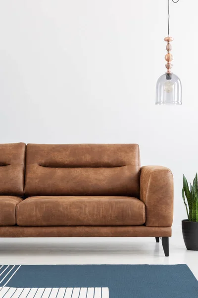 モダンなアパートメント 垂直方向のビュー 実際の写真の大きな茶色の革のソファの上のスペースをコピーします — ストック写真