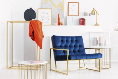 Altın aksesuarlar ve sanat, gerçek bir fotoğraf çok şık beyaz oturma odası ortasında benzin mavi kanepe