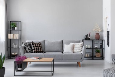 Modern kanepe, metal raf ve endüstriyel sehpa, gerçek bir fotoğraf ile İskandinav oturma odası duvar alanı Kopyala