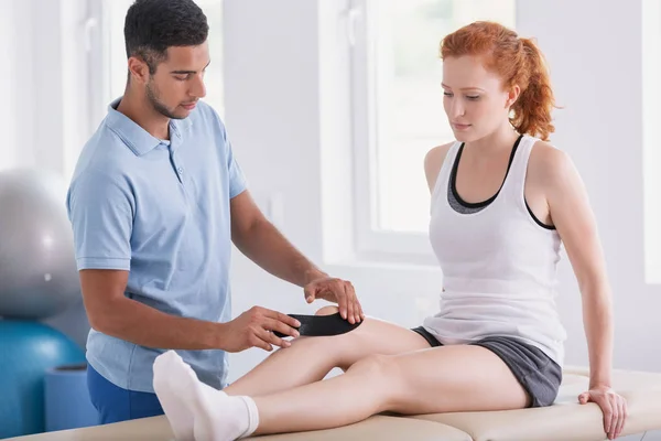 Physiotherapeut Legt Beim Kinesiotaping Klebebänder Auf Das Bein Des Patienten — Stockfoto