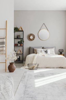 Zarif etno yatak kral ile dikey görünüm boyutu yatak, şık halı ve duvardaki ayna gerçek kopya alanı ile fotoğraf