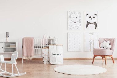 Beyaz mobilya ve pembe vurgular, şık İskandinav kreş kopya alanı beyaz boş duvar üzerinde şirin poster