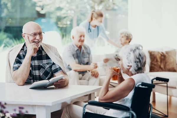 Ler Äldre Man Läsa Bok Och Pratar Med Förlamade Senior — Stockfoto