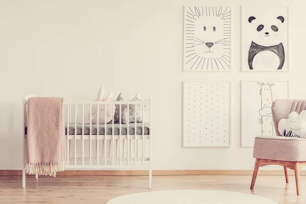 明亮的婴儿房 白色托儿所 可爱的枕头和粉红色的毯子 动物画在墙旁边的舒适扶手椅 — 图库照片