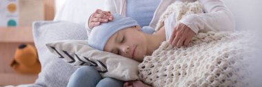 Panorama of caregiver supporting sleeping sick child with cancer in the hospice clipart