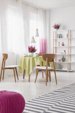 Parlak yemek odası iç kumaş ve heather, perdeler ile pencere ve ahşap raf dekor ve Kitaplar ile tablo ile gerçek fotoğraf