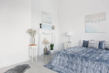 Büyük rahat yatak kopya alanı ile gerçek fotoğraf zarif mavi yatak, beyaz şömine portal ve gümüş vazolar, çiçekler