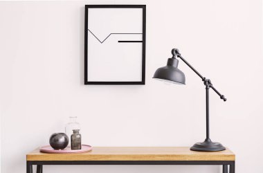 Masa lambası ve plaka cam şişeler, beyaz duvar yukarıdaki siyah çerçeve içinde posteri ile closeup