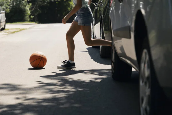車の横にある横断歩道のボールを持って走っている少女 — ストック写真