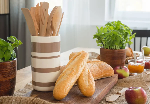 Närbild Matbord Med Baguetter Basilika Äpplen Och Behållare Med Träslevar — Stockfoto