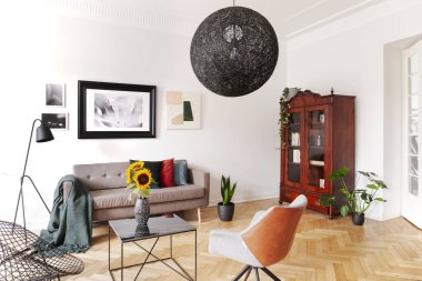 Koltuk ve kanepe düz iç lamba ve posterler ile arasında masadaki ayçiçeği. Gerçek fotoğraf