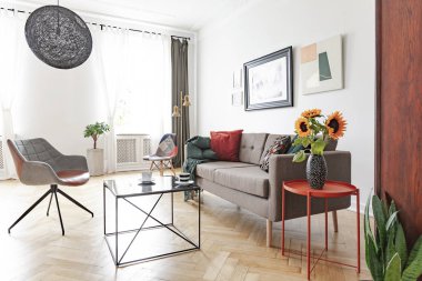Şık salon iç metal sehpa, koltuk, kanepe ve ayçiçeği ile gerçek fotoğraf