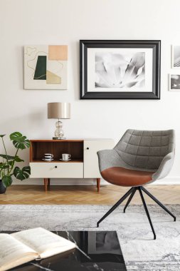 Lamba beyaz salon iç gri tekli ve duvardaki posterler dolapta. Gerçek fotoğraf