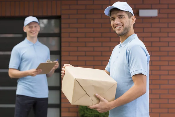 Glad Courier Blå Uniform Håller Ett Paket — Stockfoto