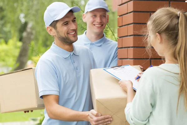 Two Smiling Couriers Blue Uniforms Young Women Filling Delivery Documents — Stock Photo, Image