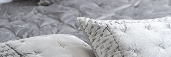 パノラマと寝室のインテリアでベッドの上の装飾的なトリムとエレガントなグレーの枕にクローズ アップ 実際の写真 — ストック写真