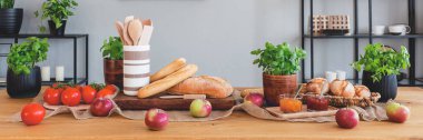 Panorama elma, domates, baget ekmek ve fesleğen yemek odası iç ahşap tablo. Gerçek fotoğraf
