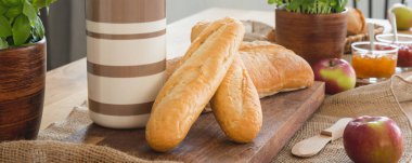 Panorama baguesttes ve konteyner ile elma yemek masası üzerinde ahşap masa üzerinde. Gerçek fotoğraf