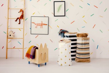 Ahşap sandık ve desenli çocuk odası iç merdiven yanında posterler üzerinde fox ile torbalarda. Gerçek fotoğraf