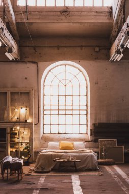 Halı battaniye ferah aydınlık çatı iç yatak ve pencere sandalyeyle yakınındaki bankta. Gerçek fotoğraf