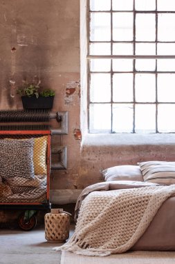 Fener yatak yastık ve pencere ile parlak çatı katı yatak odası iç battaniyeye ile yanındaki. Gerçek fotoğraf