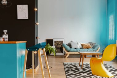 Siyah ve beyaz salon iç ev bar, birçok posterler, desenli halı ve minderler gerçek fotoğraf ile salon
