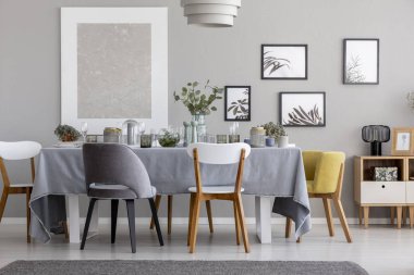 Beyaz, gri ve sarı sandalye masada Sofra yemek odası iç posterler ile ile. Gerçek fotoğraf