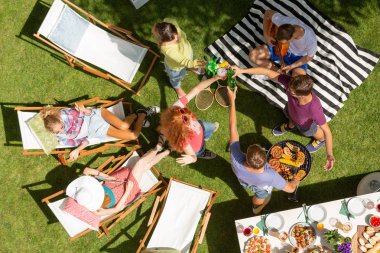 Arkadaşlar bahçede parti sırasında şişe ile tost ekmegi şezlong üzerinde yüksek açı