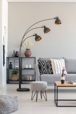 Modern lamba bir tabure ve gri oturma odası iç kanepe yanında gerçek fotoğraf