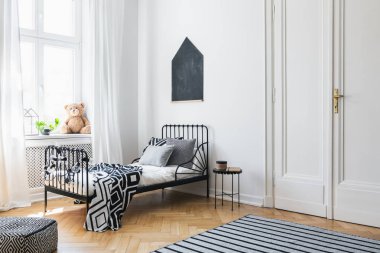 Siyah poster yatak beyaz yatak odası iç peluş oyuncak ile desenli çarşaf ile yukarıda. Gerçek fotoğraf