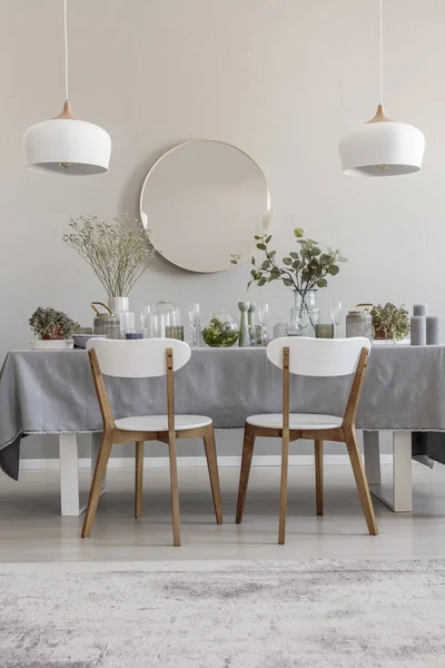 白の丸い鏡とランプ インテリアをエレガントなダイニング ルームのテーブルに椅子 実際の写真 — ストック写真