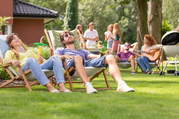 Hombre Mujer Relajándose Tumbonas Durante Fiesta Parrilla Con Amigos Jardín —  Fotos de Stock