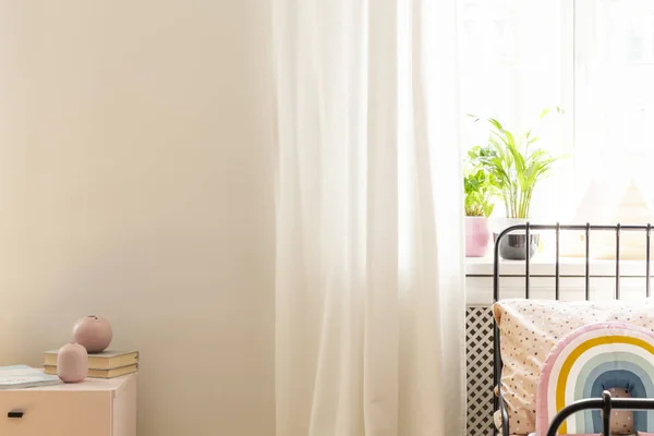 植物とコピー容量の壁と白の子供の寝室のインテリアでベッドの上のカラフルな枕 実際の写真 — ストック写真
