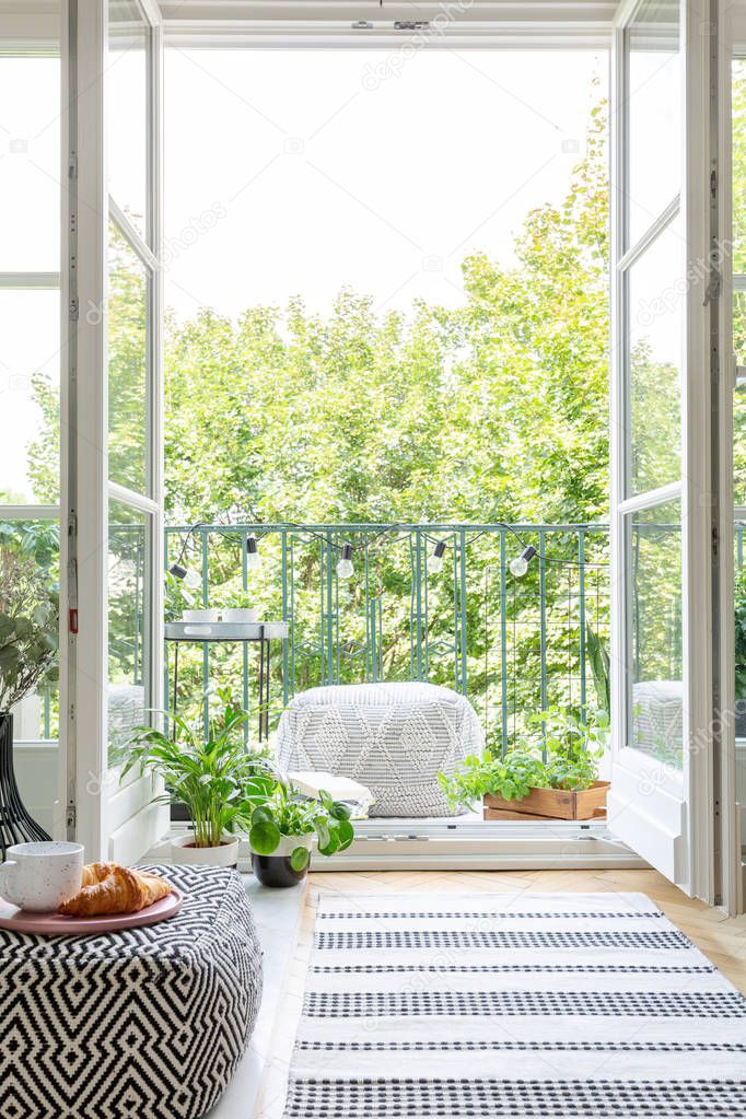 Vertical view of room with open balcony door, real photo