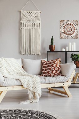 Desenli yastık ve battaniye Divan gri boho oturma odası iç posteri ile. Gerçek fotoğraf