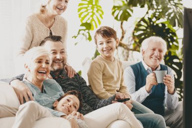 Mutlu çocuklar ve gülümseyen veliler üst düzey kişi ile Toplantı sırasında televizyon izlerken