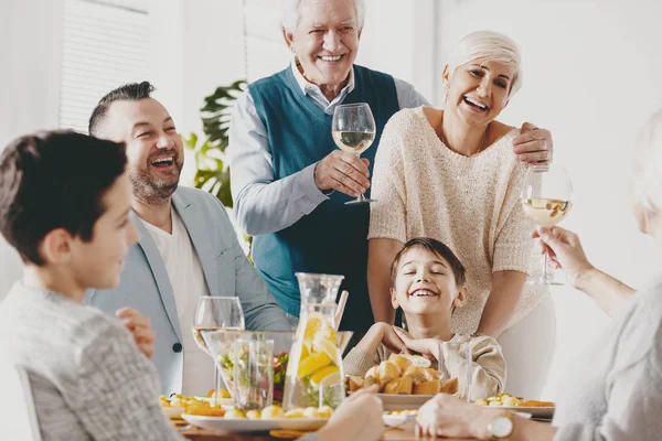 Sorrindo Avô Avó Fazendo Brinde Durante Reunião Familiar Com Criança — Fotografia de Stock