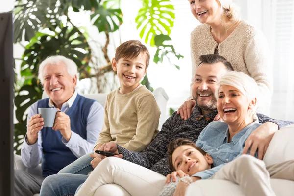 Oglądania Telewizji Szczęśliwą Rodzinę Dzieci Siedząc Obok Rodziców Uśmiechnięty Dziadek — Zdjęcie stockowe