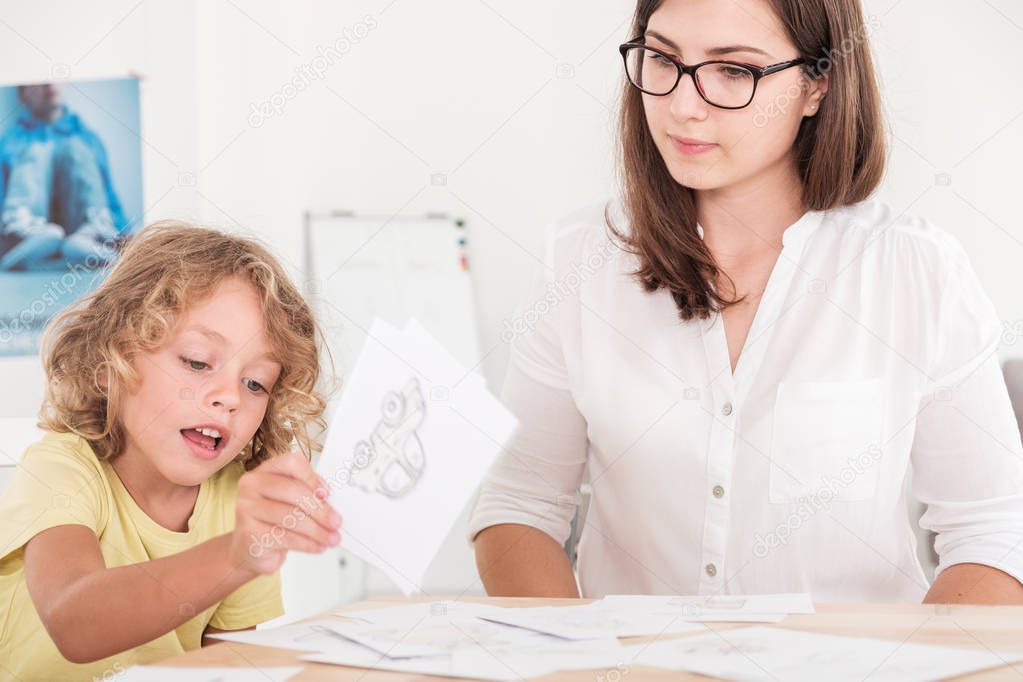 A professional child education therapist using props during a meeting with a kid with problems.