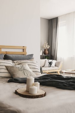 Parlak açık alan yatak odası iç pencere perdeleri ve kanepe ile gerçek fotoğraf tepsisine ahşap gövde mum ile bulanık ön plan