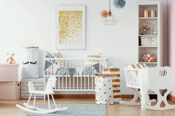 木摇马 白色和金色纸袋和白色木制婴儿床在舒适的婴儿苗圃与绘画在墙上 — 图库照片