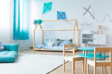 Ahşap mobilya ile çağdaş bebek yatak boş beyaz duvar ev yapımı mavi ve beyaz uçurtma