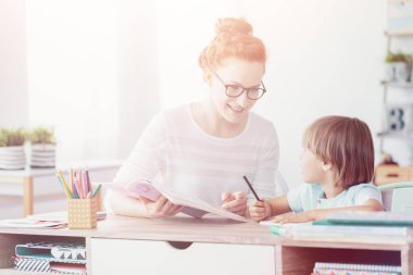 Gülümseyen öğretmen ve çocuk egzersiz sırasında müfredat sınıflar yapmak