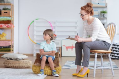 Asperger sendromu tedavisi sırasında uyuşukluk görülebilir psikiyatrist ile kabarık üzerinde oturan çocukla