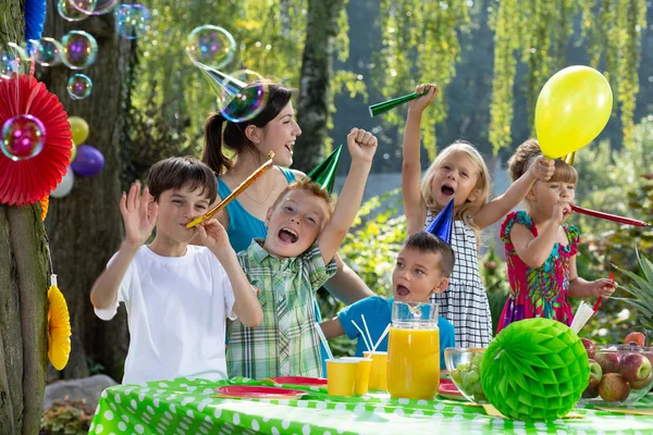 誕生日の帽子とガーデン パーティーの最中にバルーンで遊ぶ子供たち — ストック写真